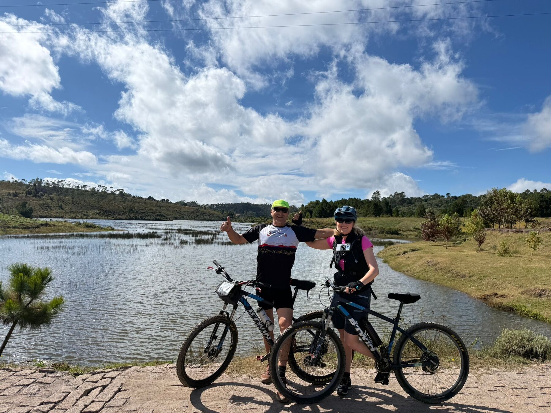 4WD Mada cyclists beside a highland lake in Madagascar
